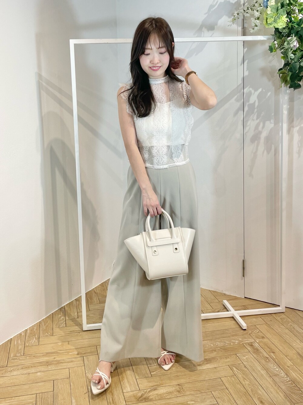 ホワイト系のトートバッグ、ホワイト系のサンダル、グリーン系のその他パンツを着用したレディースの夏コーディネートの2枚目の写真