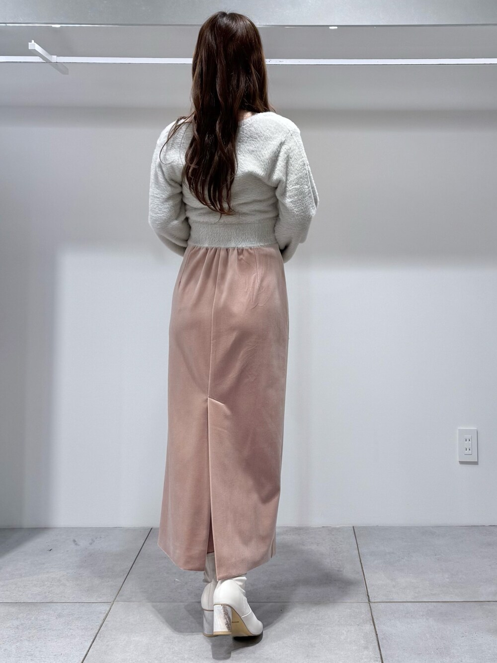 グレー系のカーディガン/ボレロ、ピンク系のスカート、ホワイト系のハンドバッグを着用したレディースの冬コーディネートの4枚目の写真