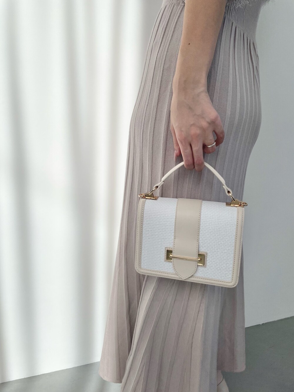 ベージュ系のワンピース、ホワイト系のハンドバッグ、ホワイト系のブーツを着用したレディースの春コーディネートの6枚目の写真