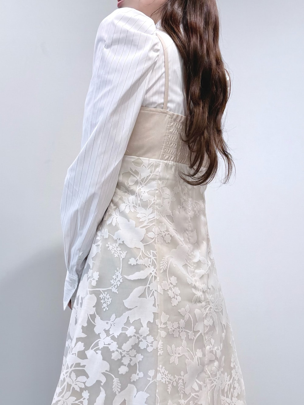 ベージュ系のワンピース、ホワイト系のパンプスを着用したレディースの冬コーディネートの6枚目の写真