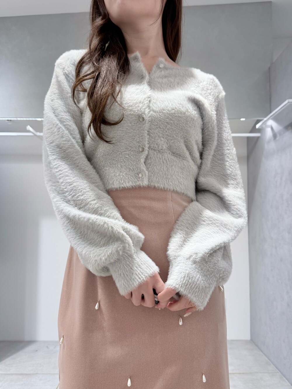 グレー系のカーディガン/ボレロ、ピンク系のスカート、ホワイト系のハンドバッグを着用したレディースの冬コーディネートの5枚目の写真