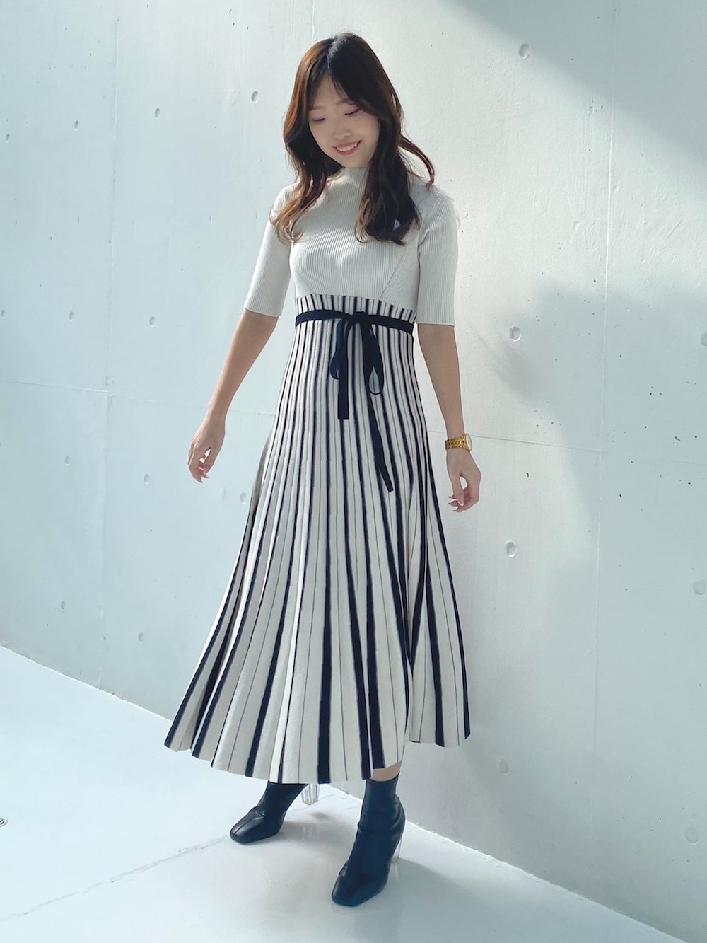 ホワイト系のワンピース、ベージュ系のライダースジャケットを着用したレディースの春コーディネートの6枚目の写真