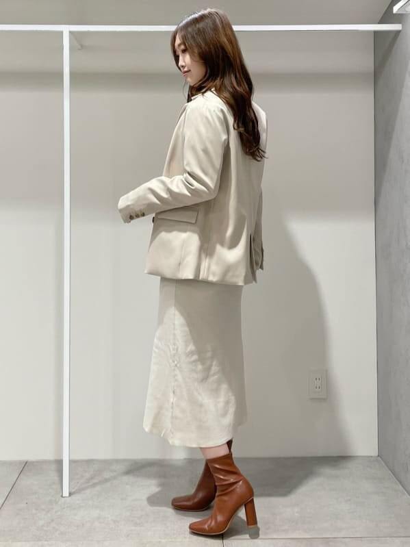 ブラウン系のブーツ、ベージュ系のテーラードジャケット、ホワイト系のワンピースを着用したレディースの秋コーディネートの5枚目の写真