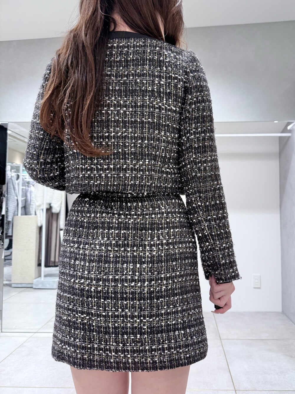 ブラック系のスカート、ホワイト系のハンドバッグ、ブラック系のテーラードジャケットを着用したレディースの冬コーディネートの7枚目の写真