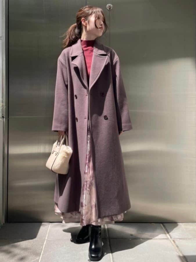 ホワイト系のハンドバッグ、ブラウン系のチェスターコート、レッド系のニット/セーターを着用したレディースの秋コーディネートの2枚目の写真