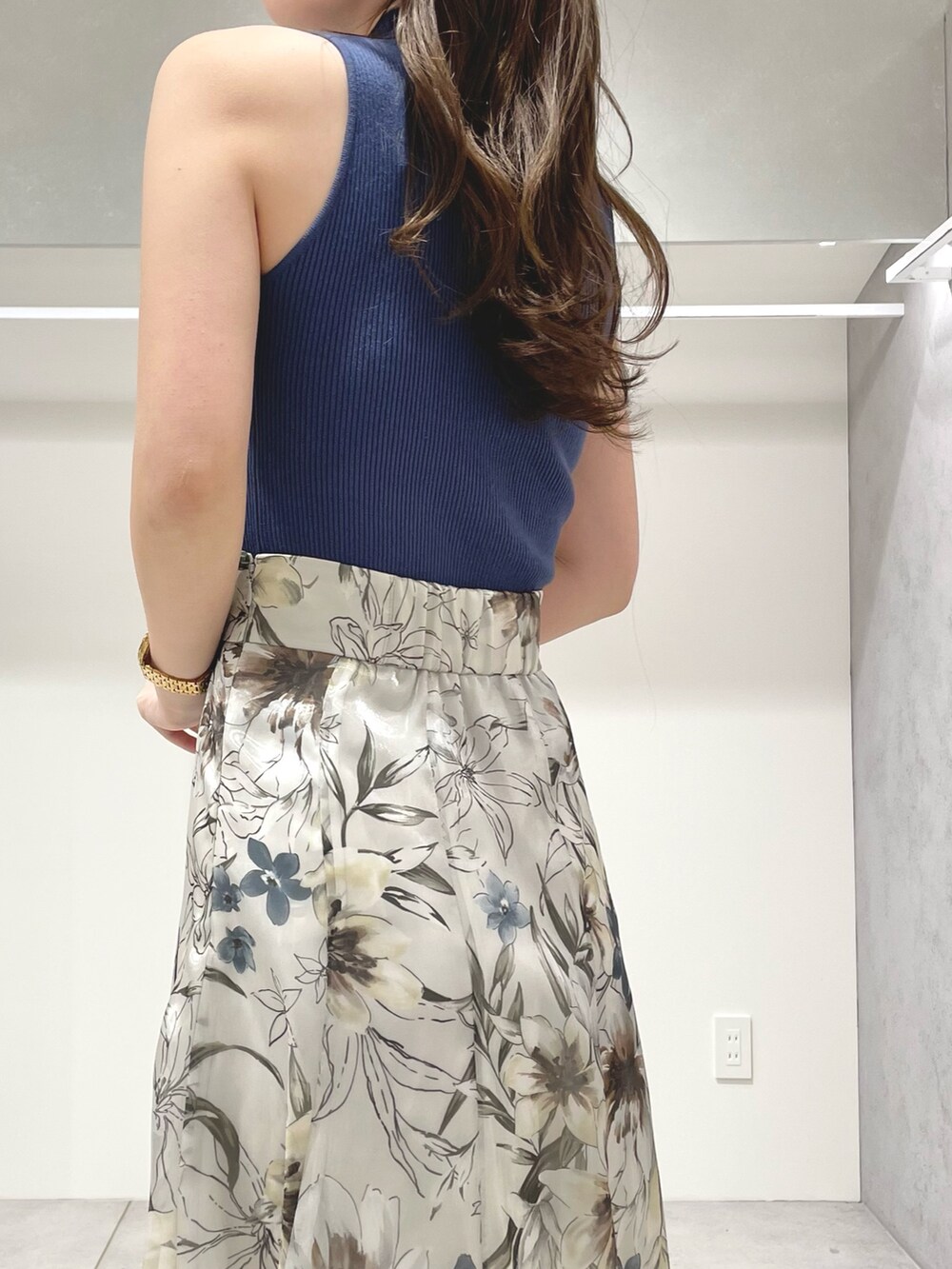 ホワイト系のベスト、グリーン系のスカート、ブルー系のニット/セーターを着用したレディースの春コーディネートの9枚目の写真