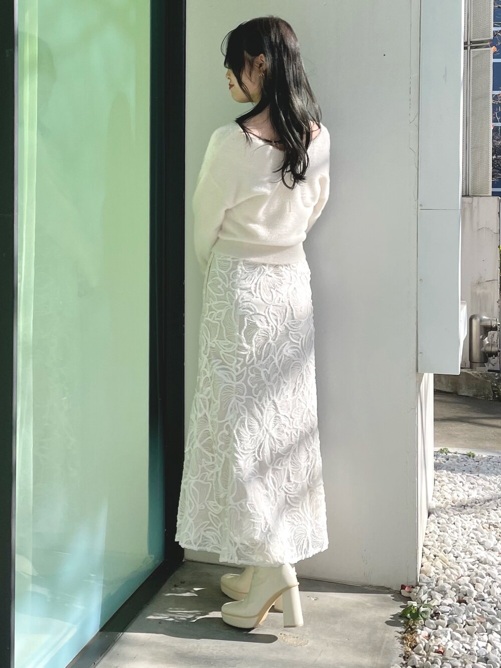 ホワイト系のダウンジャケット/コート、ホワイト系のニット/セーター、ホワイト系のスカートを着用したレディースの冬コーディネートの6枚目の写真