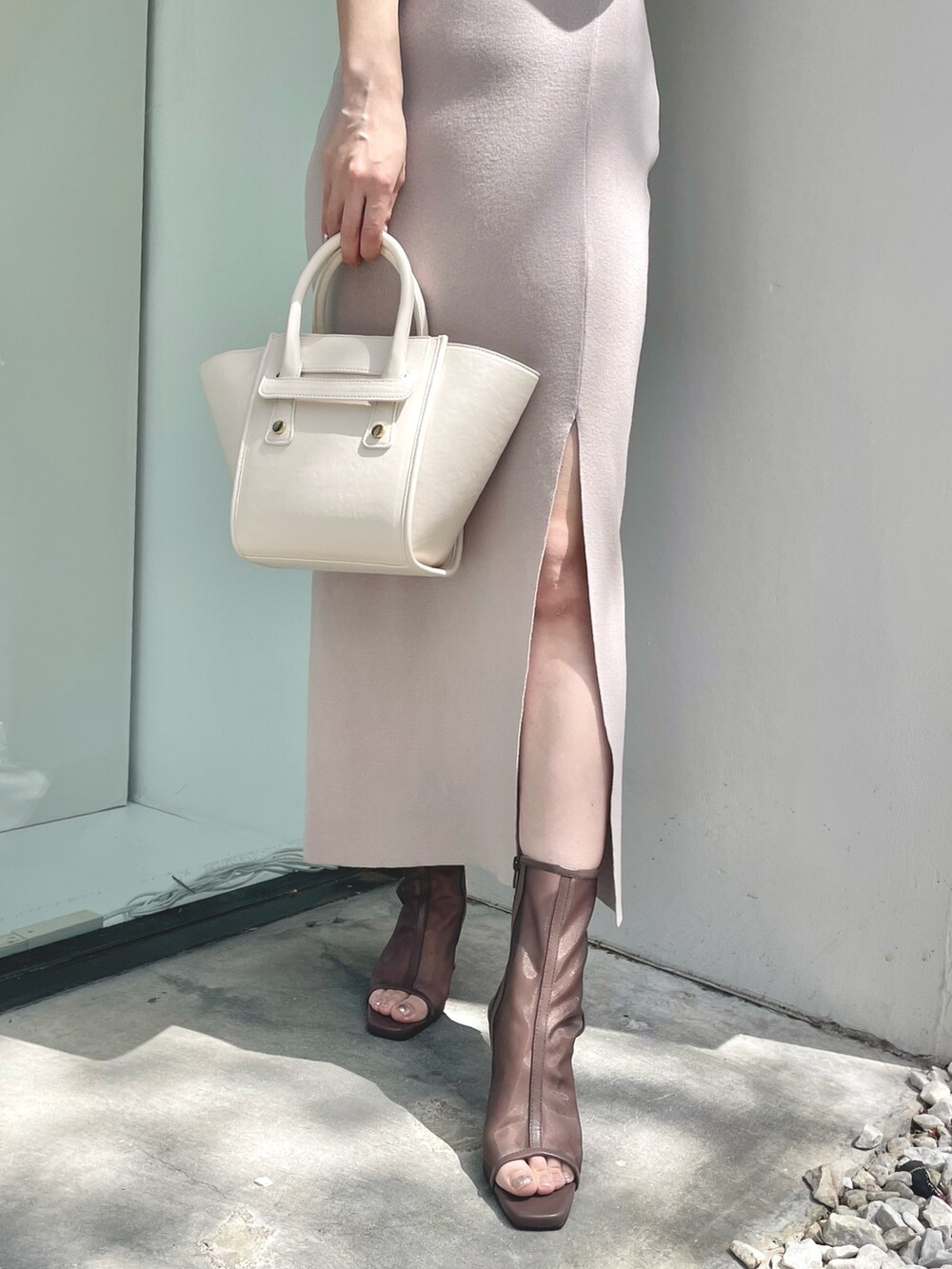 ブラウン系のブーツ、ピンク系のワンピース、ホワイト系のトートバッグを着用したレディースの春コーディネートの6枚目の写真