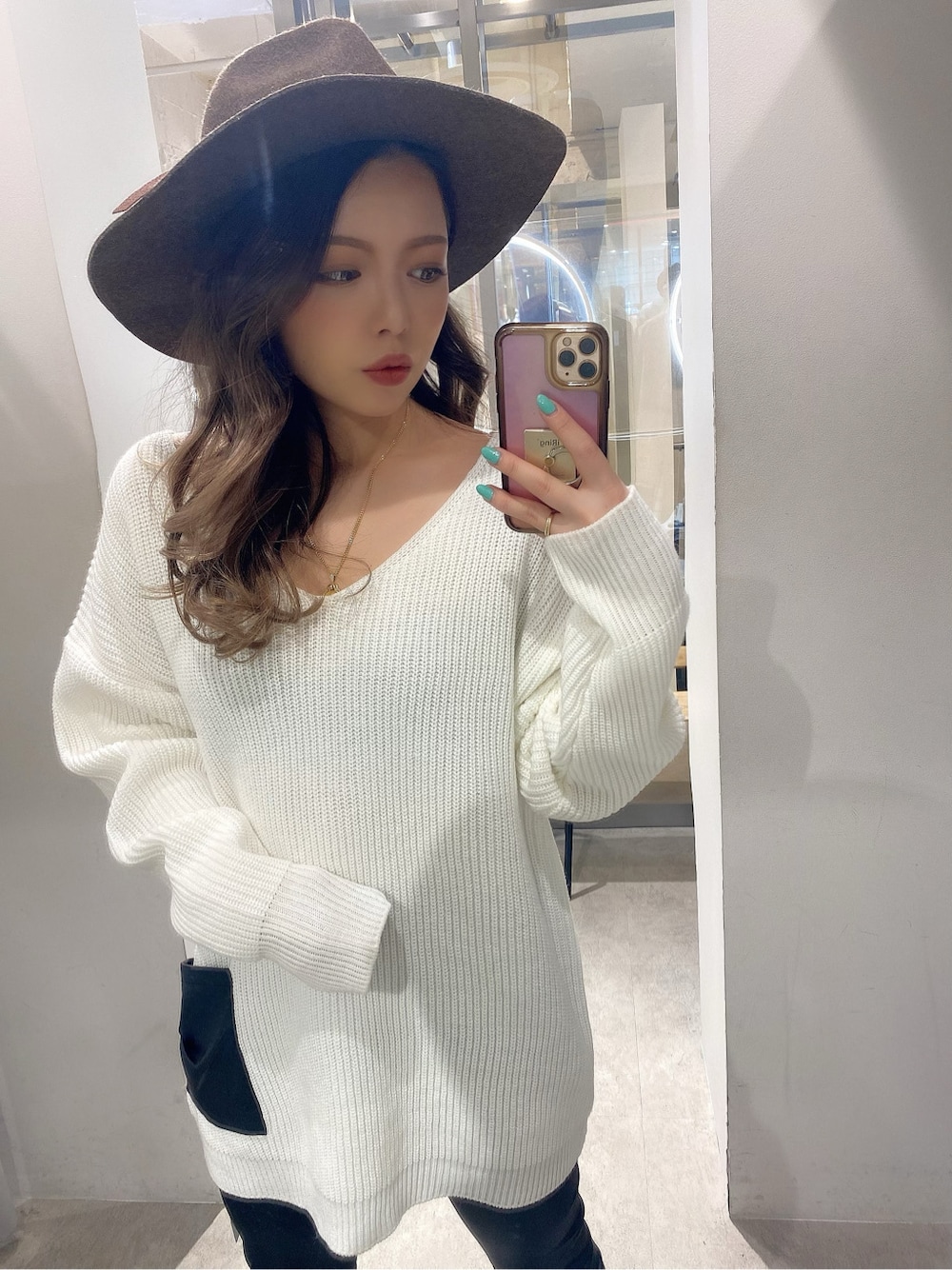 ブラック系のパンプス、ホワイト系のニット/セーター、ブラック系のレギンス/スパッツを着用したレディースの冬コーディネートの2枚目の写真