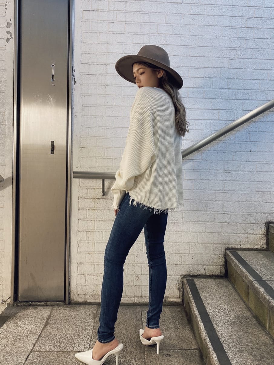 ホワイト系のパンプス、ブルー系のデニムパンツ、ホワイト系のニット/セーターを着用したレディースの夏コーディネートの2枚目の写真