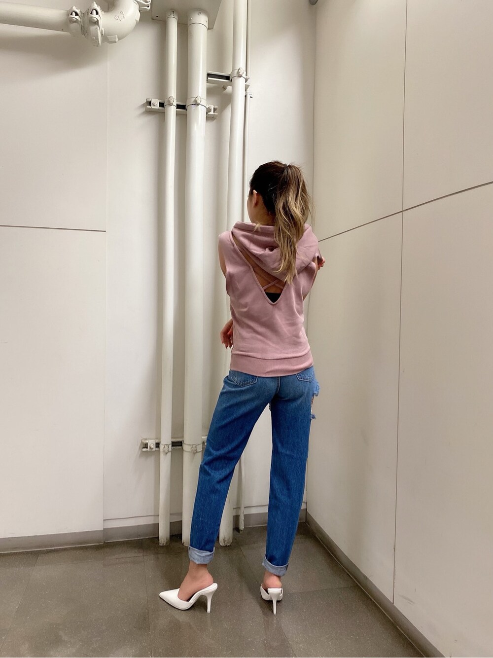 ホワイト系のパンプス、ブルー系のデニムパンツ、ピンク系のパーカーを着用したレディースの春コーディネートの2枚目の写真