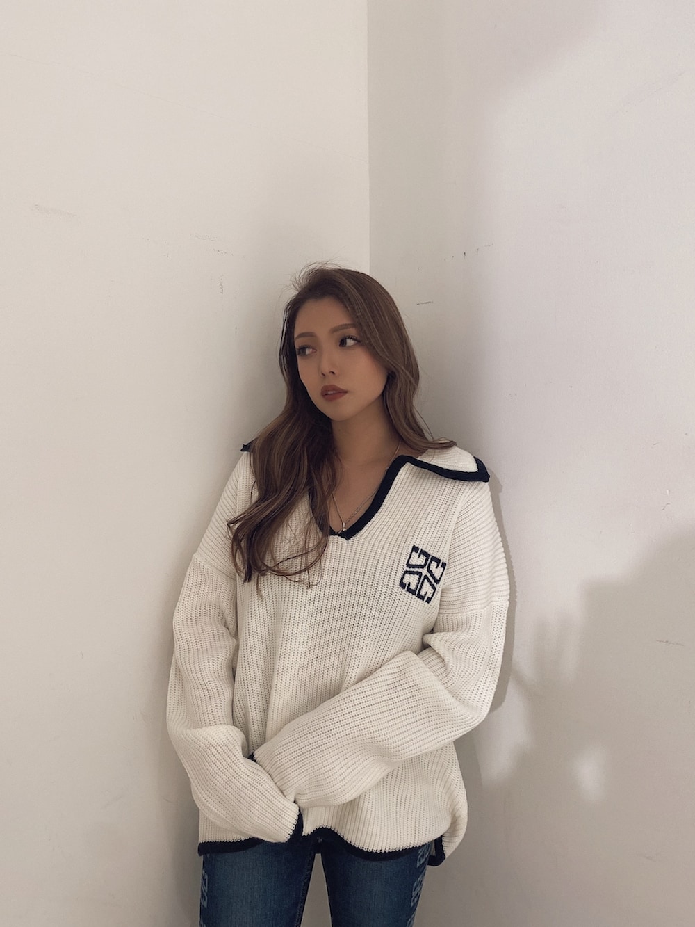 ホワイト系のニット/セーター、ブルー系のパンツ、ホワイト系のパンプスを着用したレディースの冬コーディネートの4枚目の写真