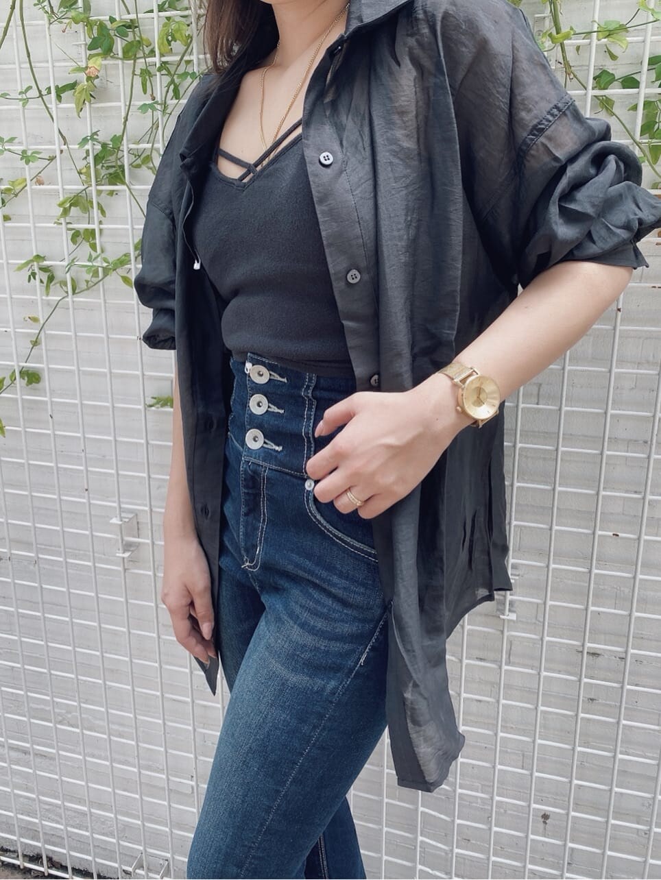 ブラック系のキャミソール、ベージュ系のサンダル、ブルー系のデニムパンツを着用したレディースの夏コーディネートの4枚目の写真