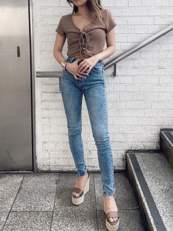 ブルー系のデニムパンツ、ベージュ系のTシャツ/カットソーを着用したレディースの夏コーディネートの3枚目の写真