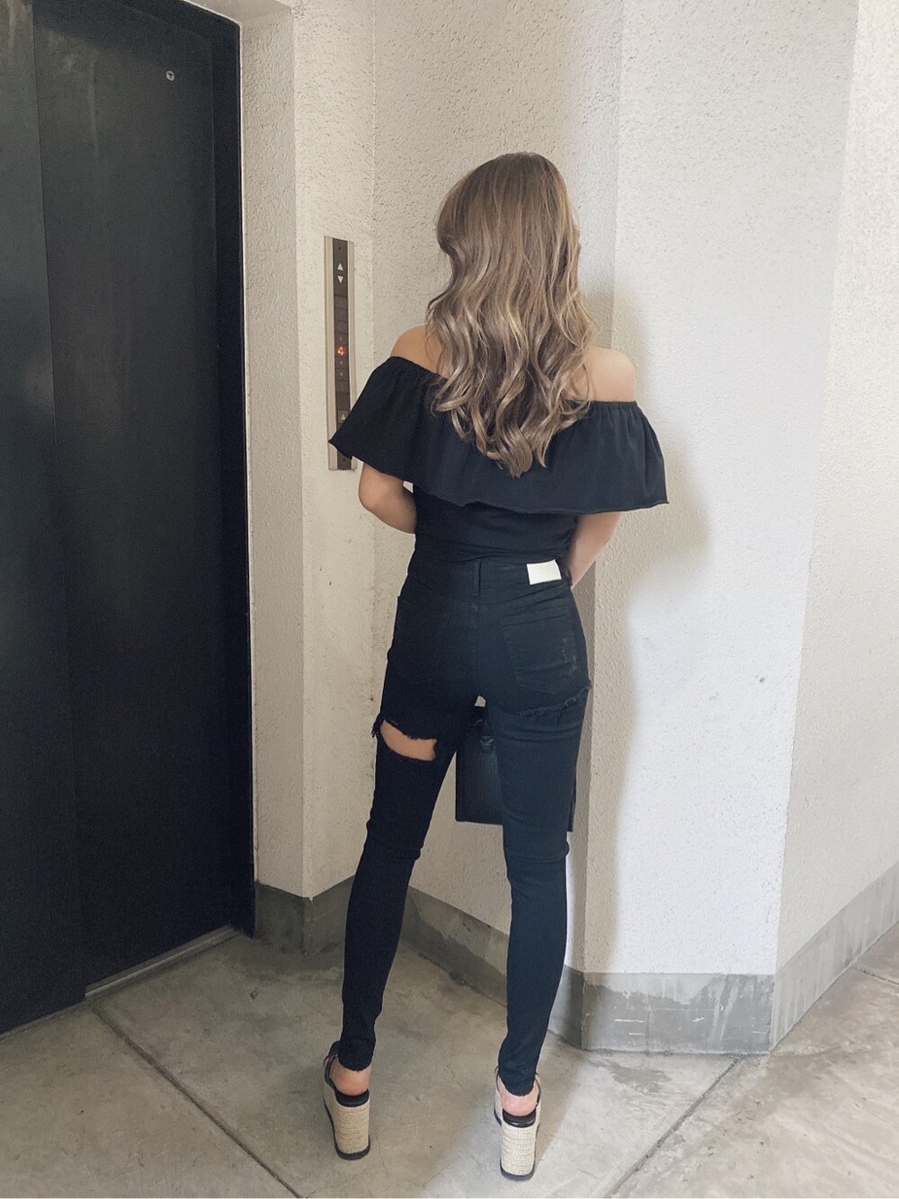 ブラック系のチノパンツ、ブラック系のサンダル、ブラック系のTシャツ/カットソーを着用したレディースの春コーディネートの3枚目の写真