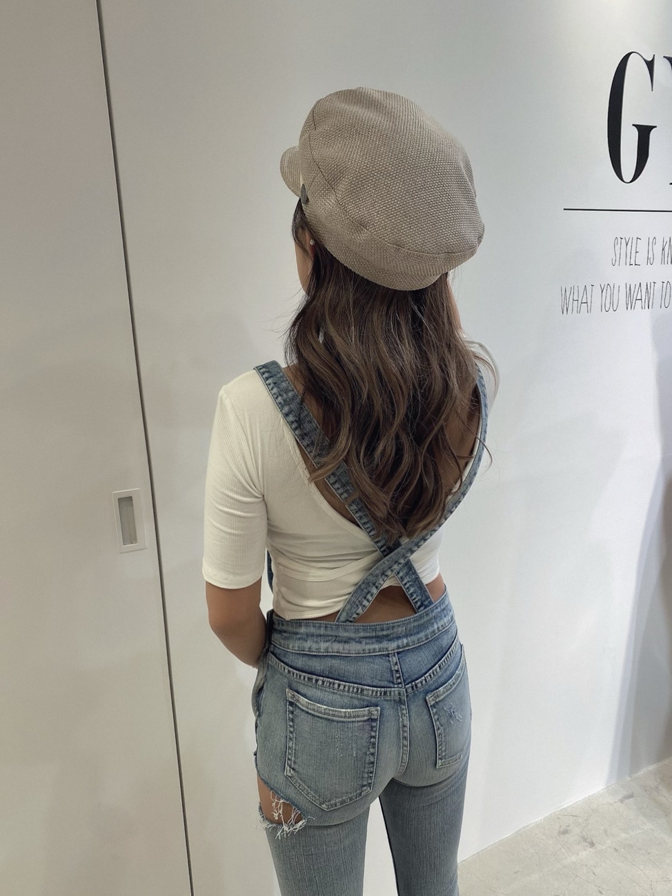 ブルー系のサロペット/オーバーオール、グリーン系のパンプス、ホワイト系のTシャツ/カットソーを着用したレディースの春コーディネートの5枚目の写真