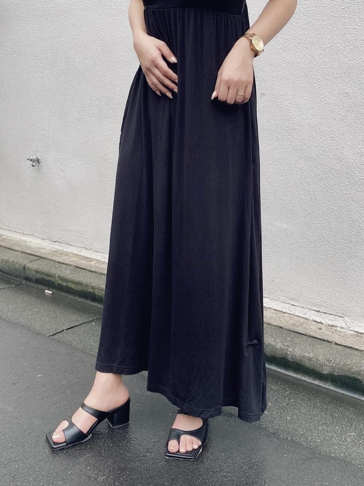 ブラック系のワンピース、ホワイト系のサンダル、ブラック系のハットを着用したレディースの夏コーディネートの5枚目の写真