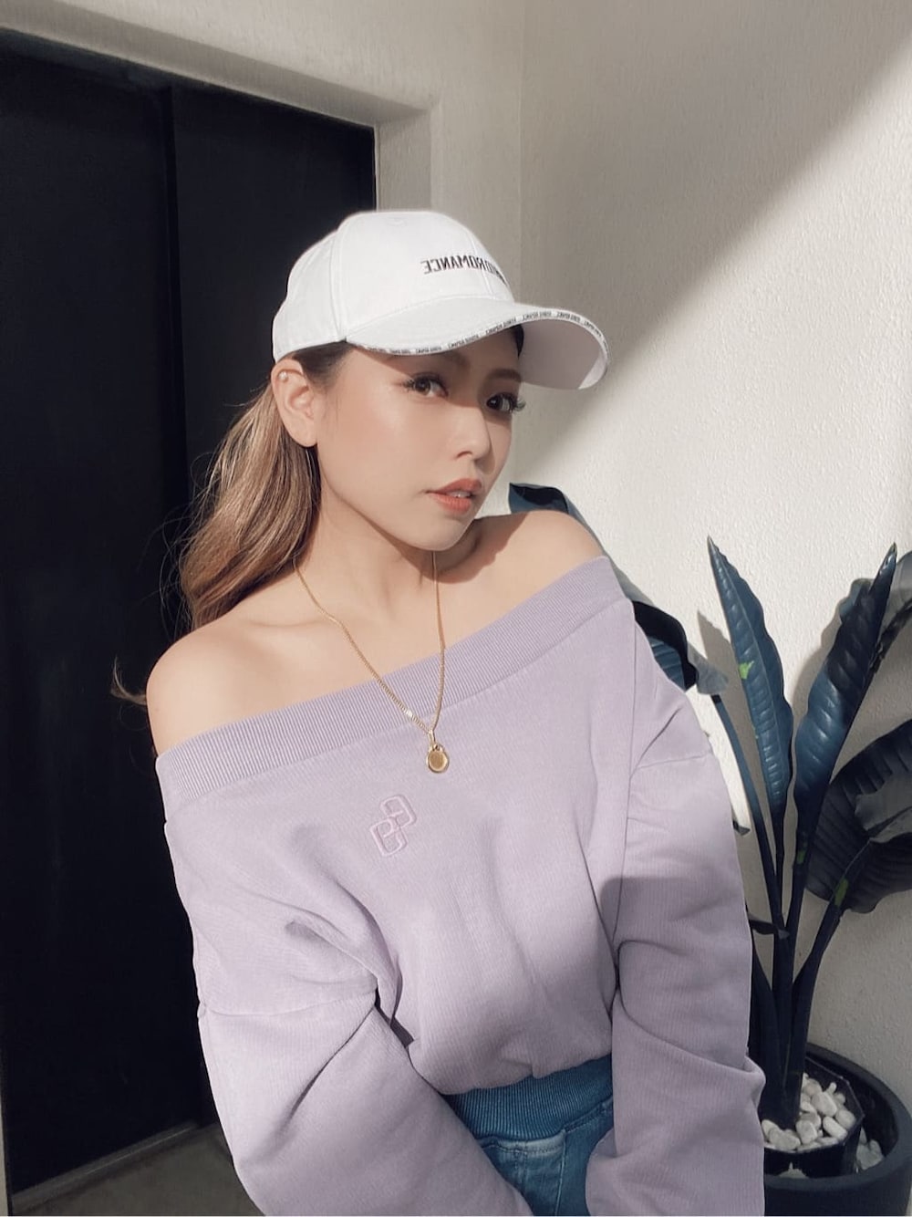 パープル系のスウェット、ブルー系のデニムパンツ、ホワイト系のパンプスを着用したレディースの冬コーディネートの4枚目の写真