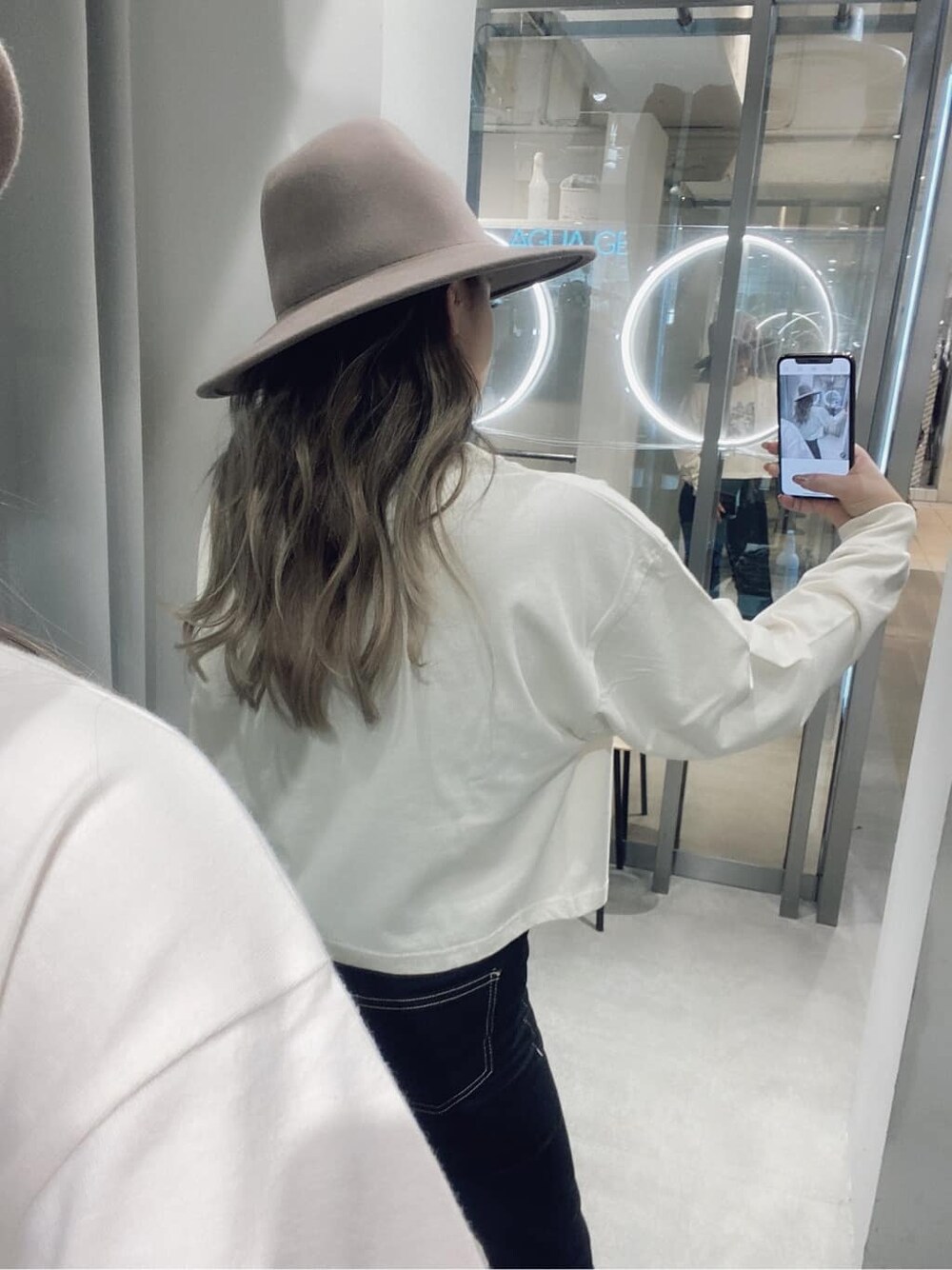 ブラック系のデニムパンツ、ブラック系のブーツ、ホワイト系のTシャツ/カットソーを着用したレディースの夏コーディネートの3枚目の写真