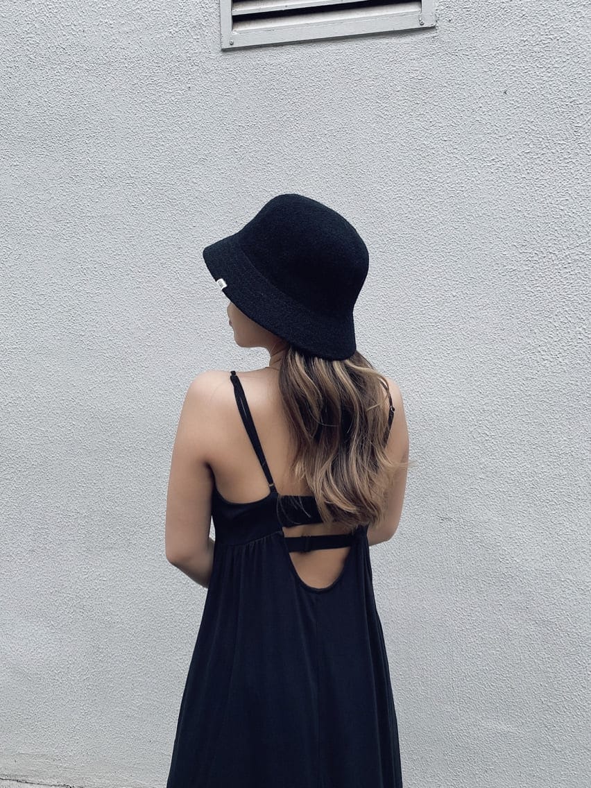 ブラック系のワンピース、ホワイト系のサンダル、ブラック系のハットを着用したレディースの夏コーディネートの4枚目の写真