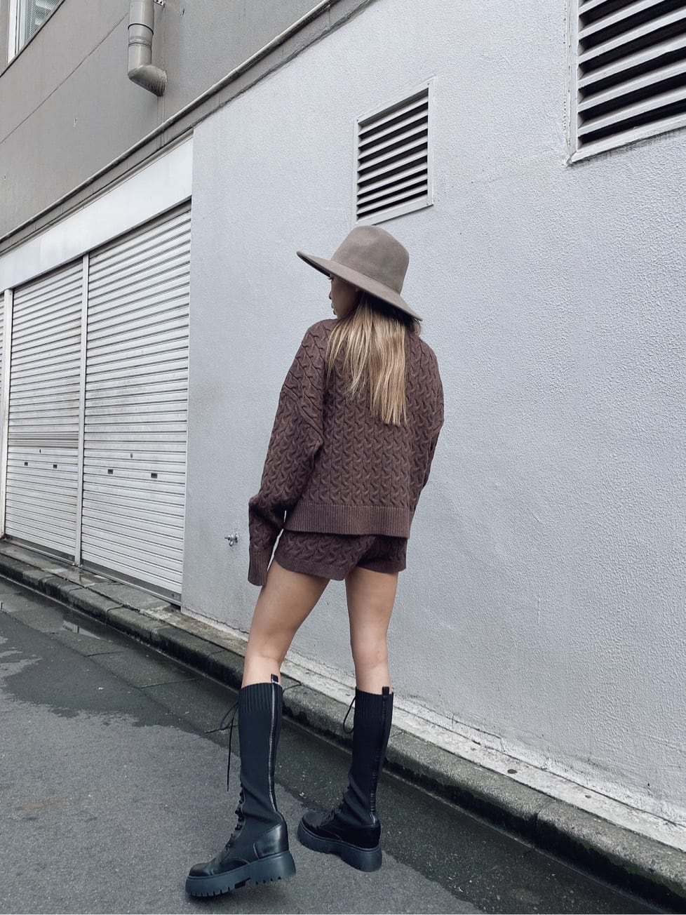 ブラウン系のその他パンツ、ブラック系のブーツ、ブラウン系のニット/セーターを着用したレディースの秋コーディネートの2枚目の写真