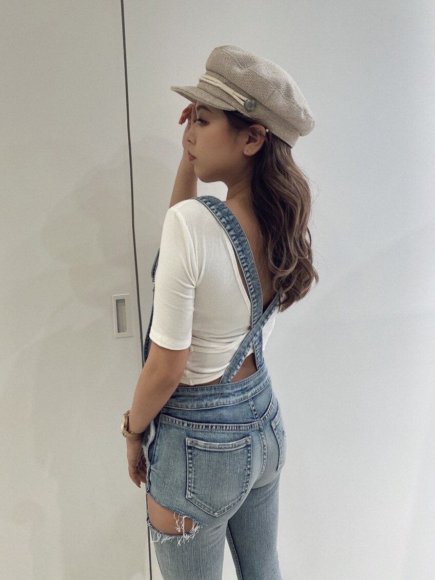 ブルー系のサロペット/オーバーオール、グリーン系のパンプス、ホワイト系のTシャツ/カットソーを着用したレディースの春コーディネートの2枚目の写真