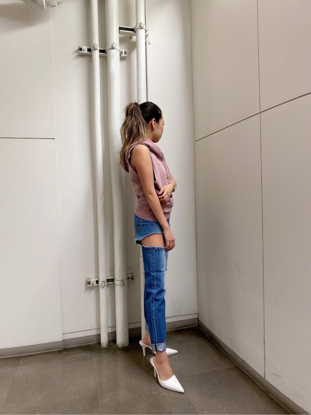 ホワイト系のパンプス、ブルー系のデニムパンツ、ピンク系のパーカーを着用したレディースの春コーディネートの3枚目の写真