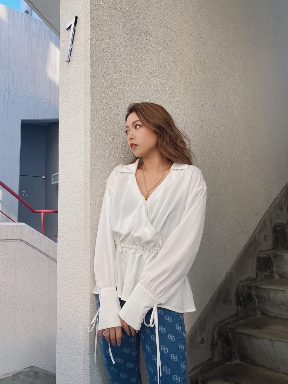 ブルー系のデニムパンツ、ホワイト系のパンプス、ホワイト系のシャツ/ブラウスを着用したレディースの冬コーディネートの3枚目の写真
