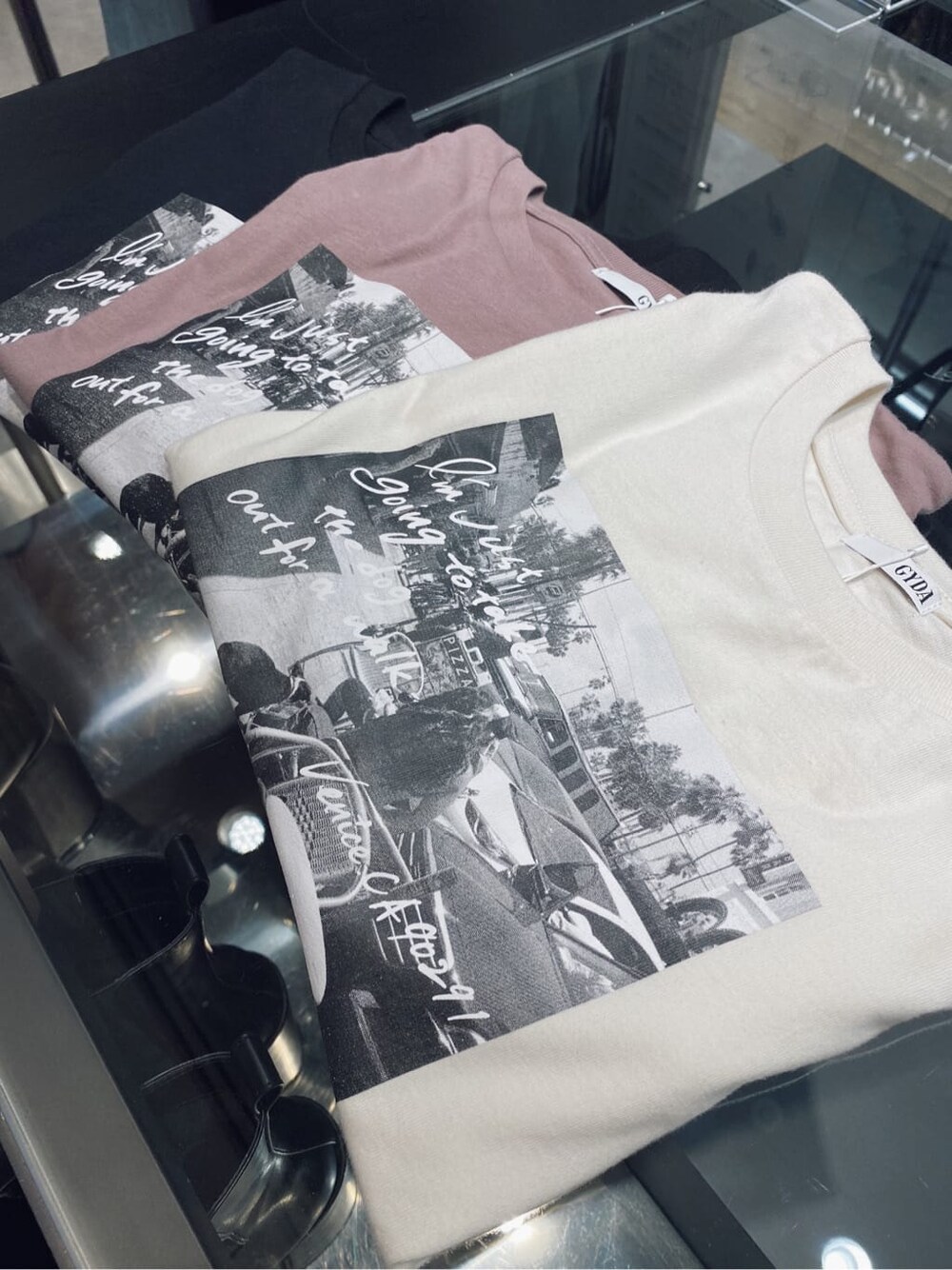 ブラック系のデニムパンツ、ブラック系のブーツ、ホワイト系のTシャツ/カットソーを着用したレディースの夏コーディネートの5枚目の写真