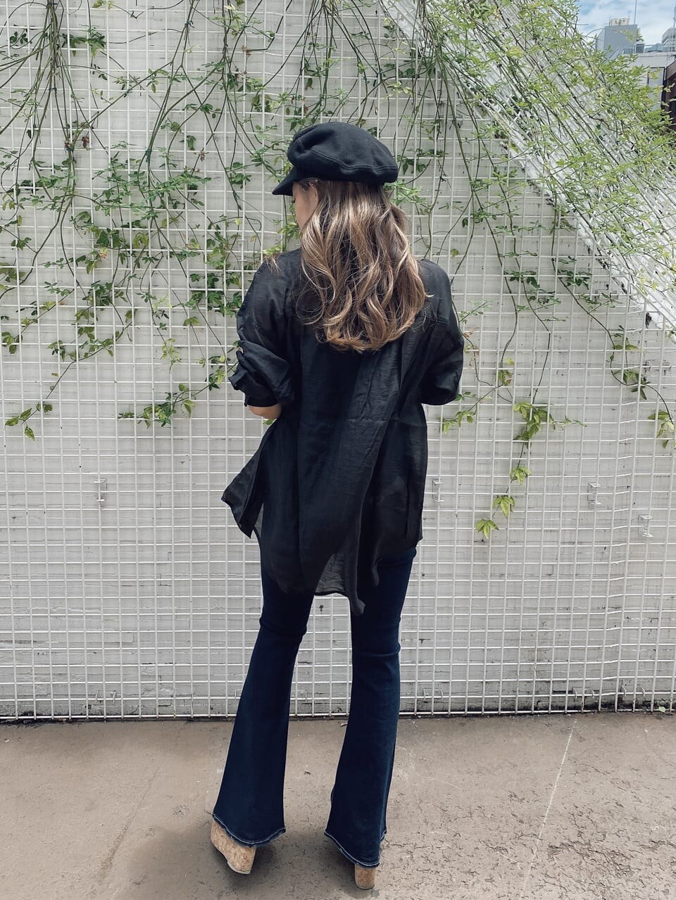 ブラック系のキャミソール、ベージュ系のサンダル、ブルー系のデニムパンツを着用したレディースの夏コーディネートの2枚目の写真