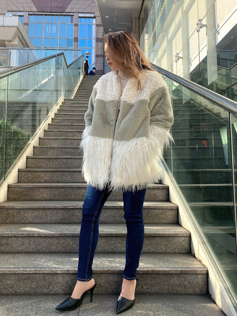 ブラック系のパンプス、ホワイト系のニット/セーター、ブルー系のデニムパンツを着用したレディースの冬コーディネートの2枚目の写真