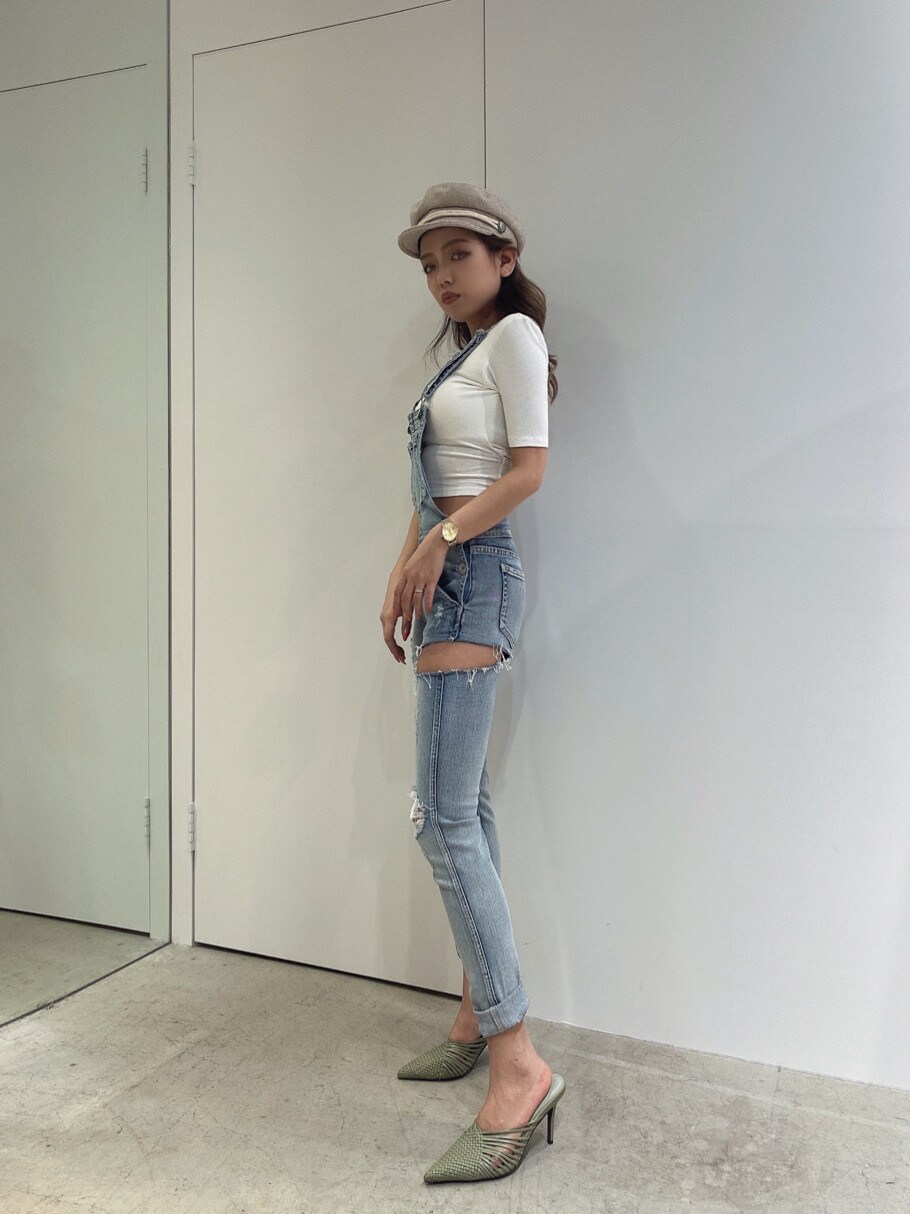 ブルー系のサロペット/オーバーオール、グリーン系のパンプス、ホワイト系のTシャツ/カットソーを着用したレディースの春コーディネートの3枚目の写真