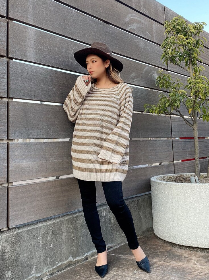 ベージュ系のニット/セーター、ブラウン系のハットを着用したレディースの冬コーディネートの2枚目の写真