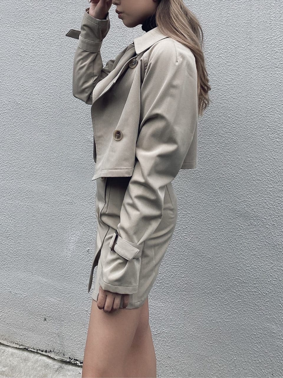 ベージュ系のスカート、ベージュ系のトレンチコート、ブラック系のブーツを着用したレディースの秋コーディネートの5枚目の写真