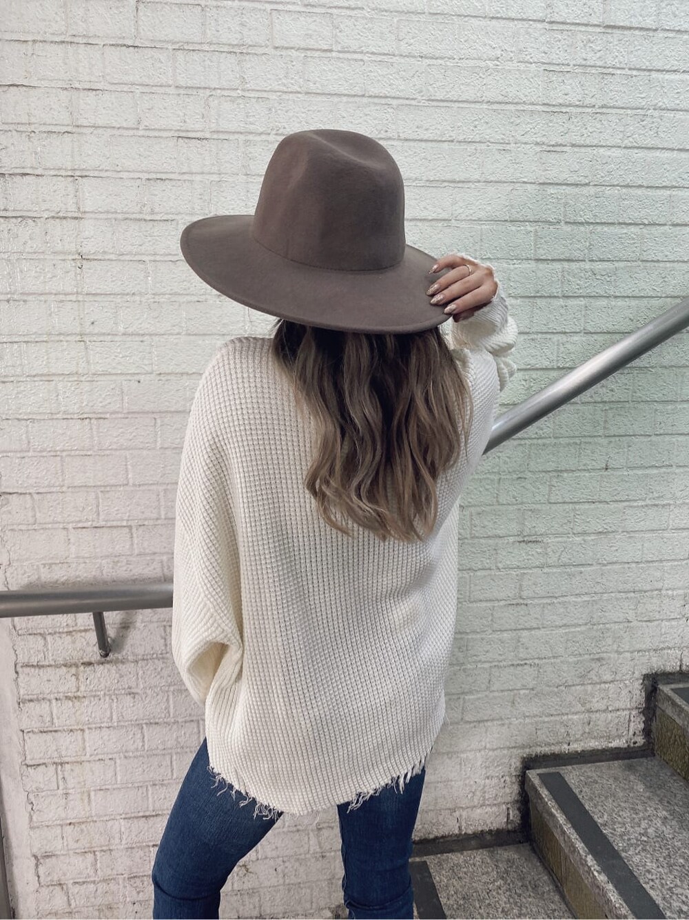 ホワイト系のパンプス、ブルー系のデニムパンツ、ホワイト系のニット/セーターを着用したレディースの夏コーディネートの5枚目の写真