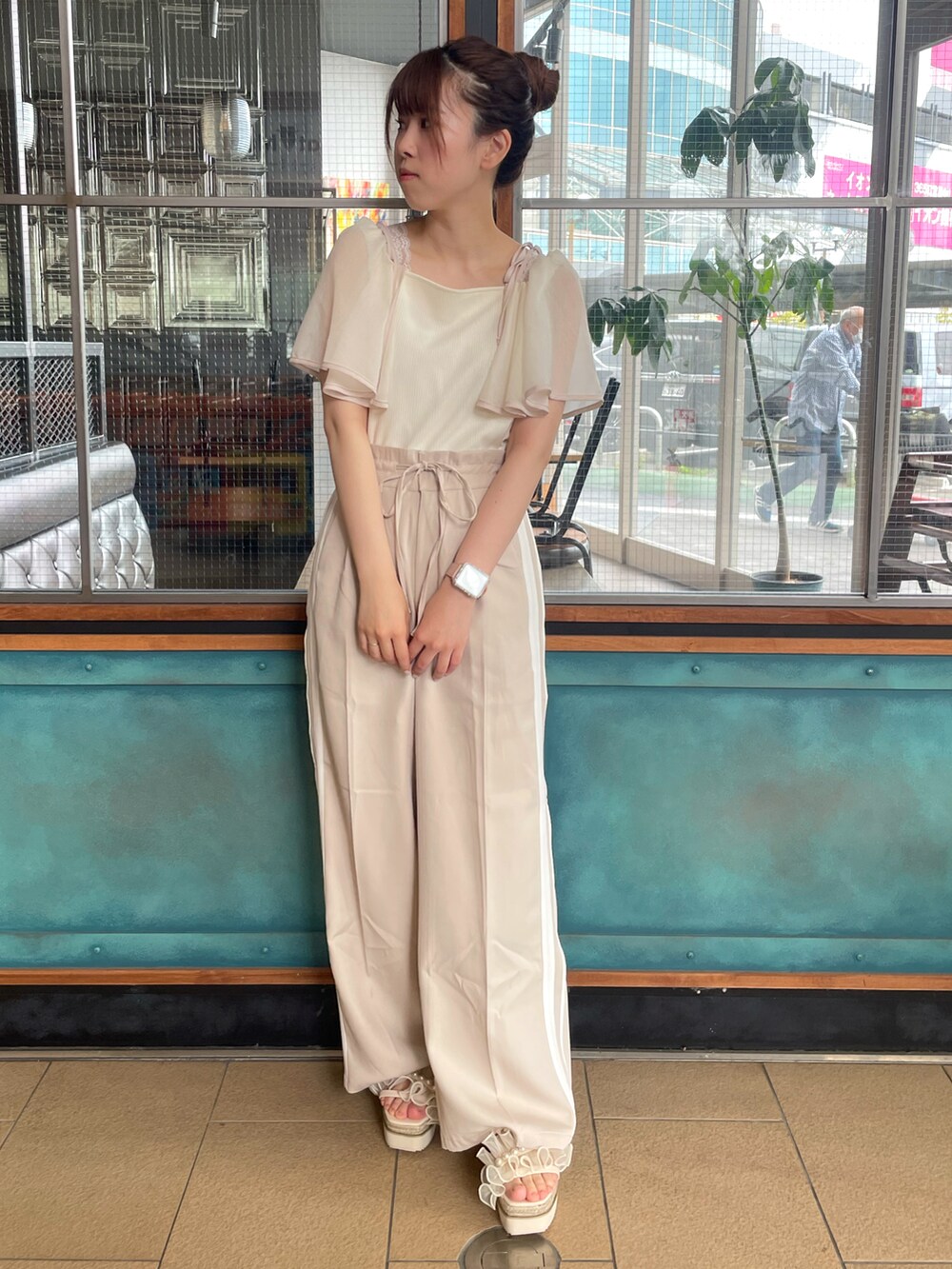 ホワイト系のTシャツ/カットソー、ベージュ系のスラックスを着用したレディースの春コーディネートの3枚目の写真