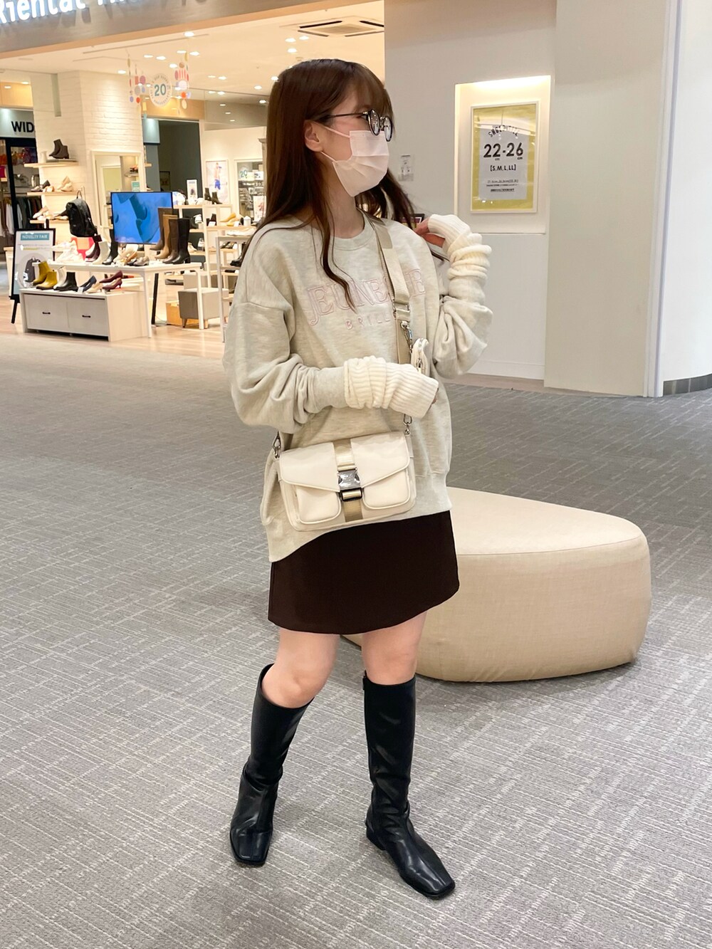 ベージュ系のスウェット、ホワイト系のショルダーバッグ、ブラウン系のスカートを着用したレディースの秋コーディネートの2枚目の写真