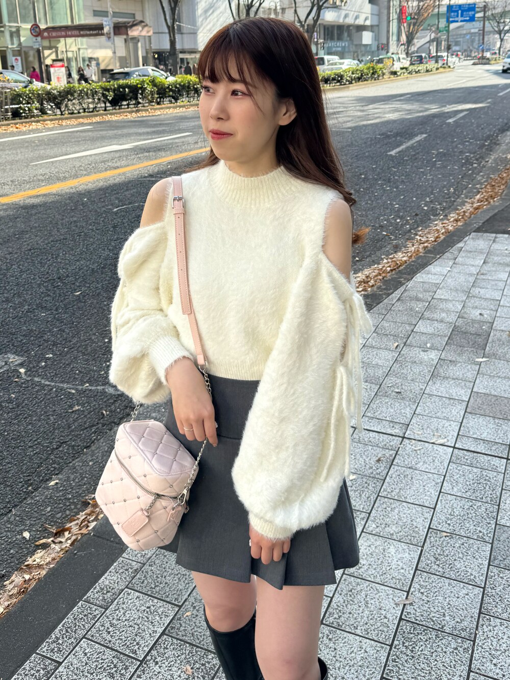 ホワイト系のニット/セーター、グレー系のスカート、ピンク系のショルダーバッグを着用したレディースの冬コーディネートの5枚目の写真