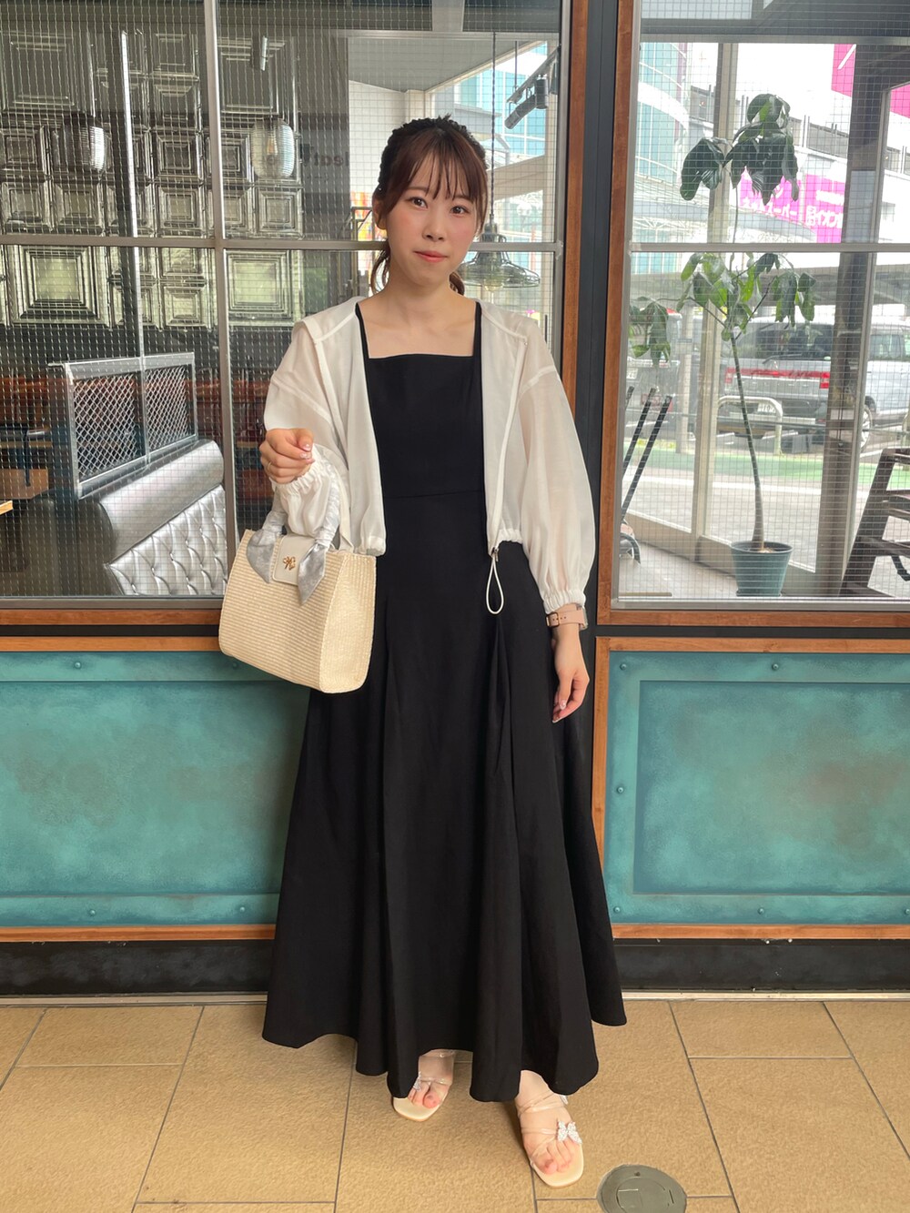 ホワイト系のマウンテンパーカー、ブラック系のワンピース、ホワイト系のショルダーバッグを着用したレディースの春コーディネートの2枚目の写真