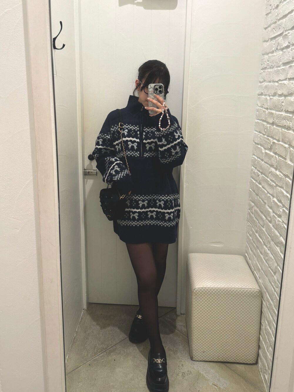 ブルー系のチュニック、ブラック系のショルダーバッグを着用したレディースの冬コーディネートの3枚目の写真