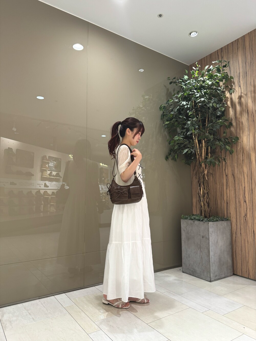 ホワイト系のカーディガン/ボレロ、ホワイト系のワンピース/ドレス、ブラウン系のショルダーバッグを着用したレディースの夏コーディネートの4枚目の写真