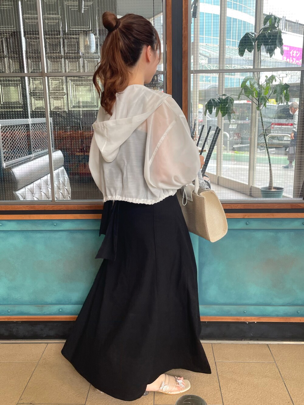 ホワイト系のマウンテンパーカー、ブラック系のワンピース、ホワイト系のショルダーバッグを着用したレディースの春コーディネートの4枚目の写真