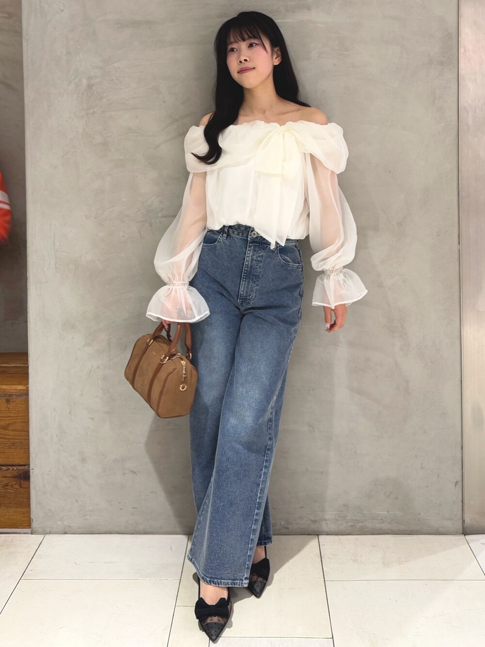 ホワイト系のシャツ/ブラウス、ブルー系のデニムパンツ、イエロー系のボストンバッグを着用したレディースの春コーディネートの2枚目の写真