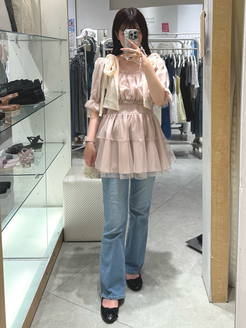 ホワイト系のシャツ/ブラウス、ホワイト系のショルダーバッグ、ブルー系のデニムパンツを着用したレディースの夏コーディネートの3枚目の写真