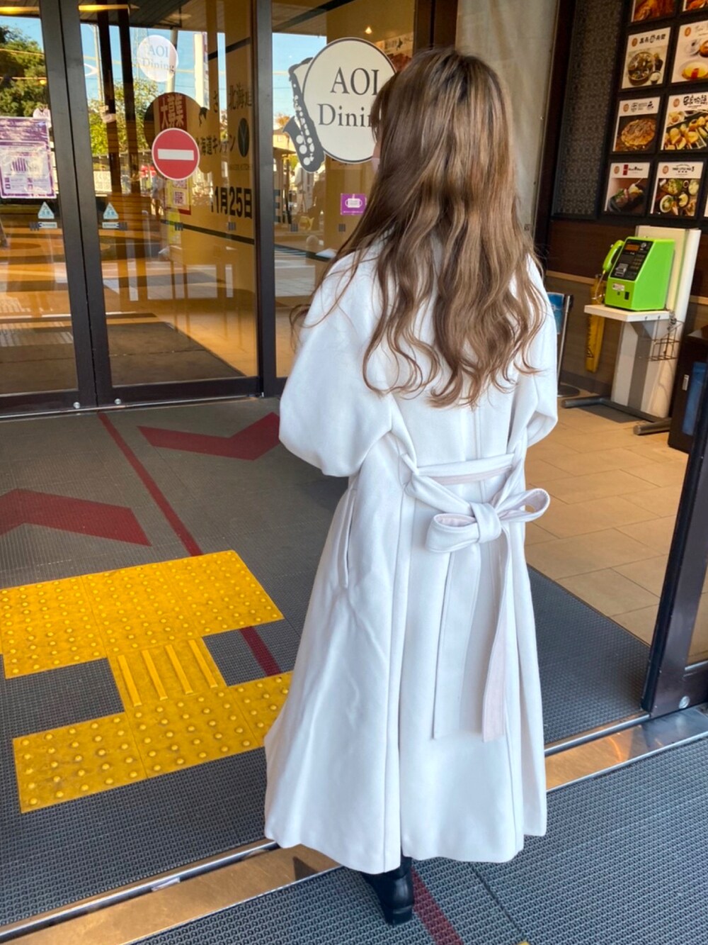 ホワイト系のステンカラーコートを着用したレディースの秋コーディネートの4枚目の写真