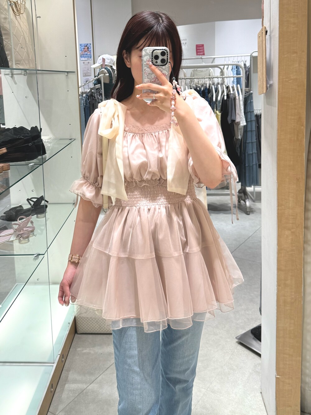 ホワイト系のシャツ/ブラウス、ホワイト系のショルダーバッグ、ブルー系のデニムパンツを着用したレディースの夏コーディネートの4枚目の写真