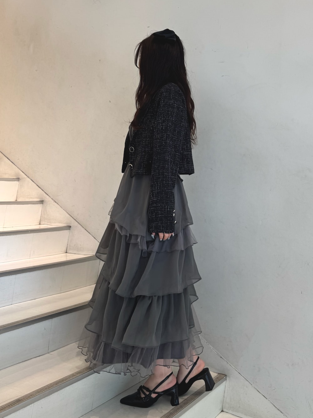 ブラック系のテーラードジャケット、グレー系のワンピース、ブラック系のショルダーバッグを着用したレディースの冬コーディネートの3枚目の写真