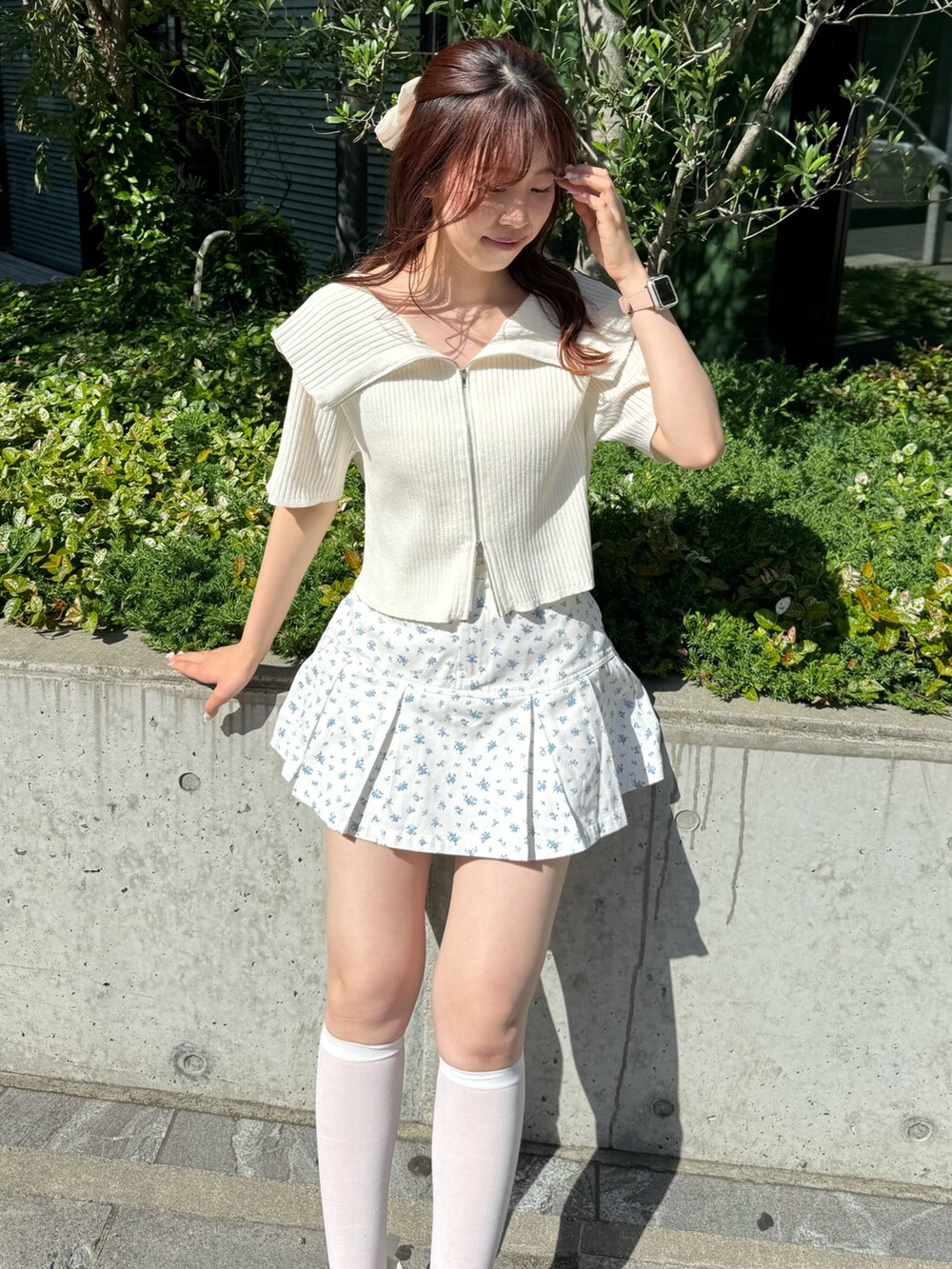 ホワイト系のニット/セーター、ブルー系のスカート、ホワイト系のスニーカーを着用したレディースの春コーディネートの4枚目の写真