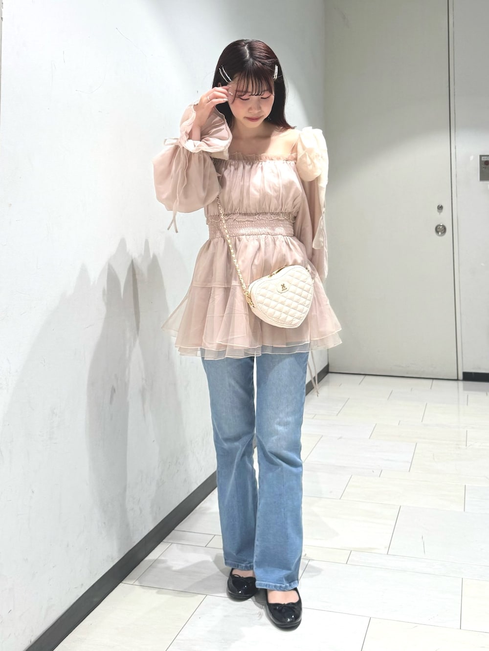 ブルー系のデニムパンツ、ベージュ系のショルダーバッグ、ピンク系のシャツ/ブラウスを着用したレディースの春コーディネートの3枚目の写真