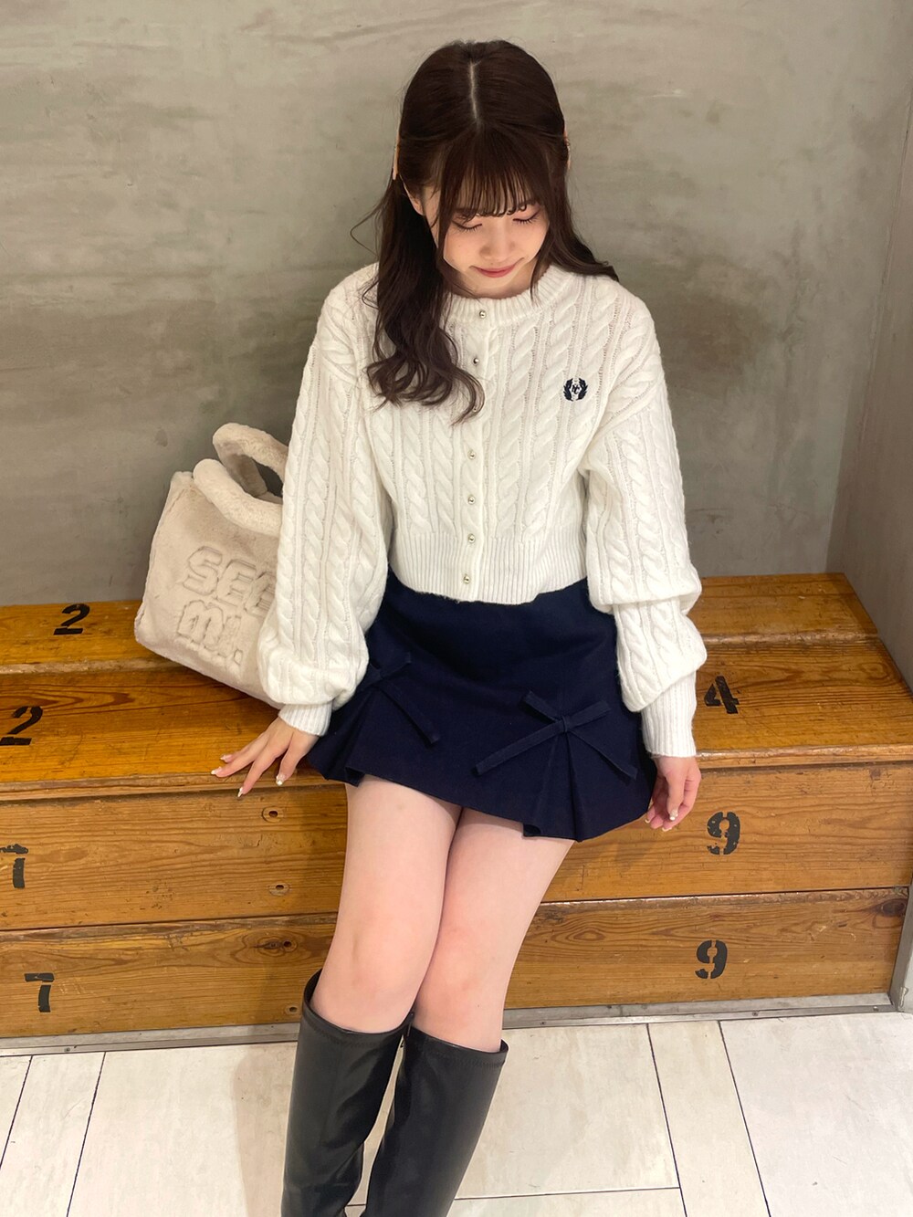 ホワイト系のカーディガン/ボレロ、ブルー系のスカート、ホワイト系のトートバッグを着用したレディースの秋コーディネートの5枚目の写真